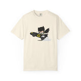 An off-white short-sleeve crewneck t-shirt featuring a cartoon graphic of Batman driving a black Batmobile with yellow accents and gray smoke, displayed on a clean white background.