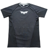 A short-sleeve athletic compression shirt styled like Batman's armor, featuring a black and dark gray honeycomb pattern with a white bat symbol on the chest, shown flat on a white background.