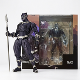 Black Panther MAX action figure standing next to its original window box packaging, holding a spear on a clean white background.