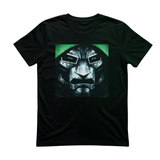 A black short-sleeve crewneck t-shirt featuring a square graphic print of a metallic sci-fi face mask with glowing green accents, displayed against a solid white background.