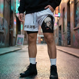 A person standing in a city alley wearing white athletic shorts with black graphics and text, a black hoodie, white socks, and black high-top shoes.