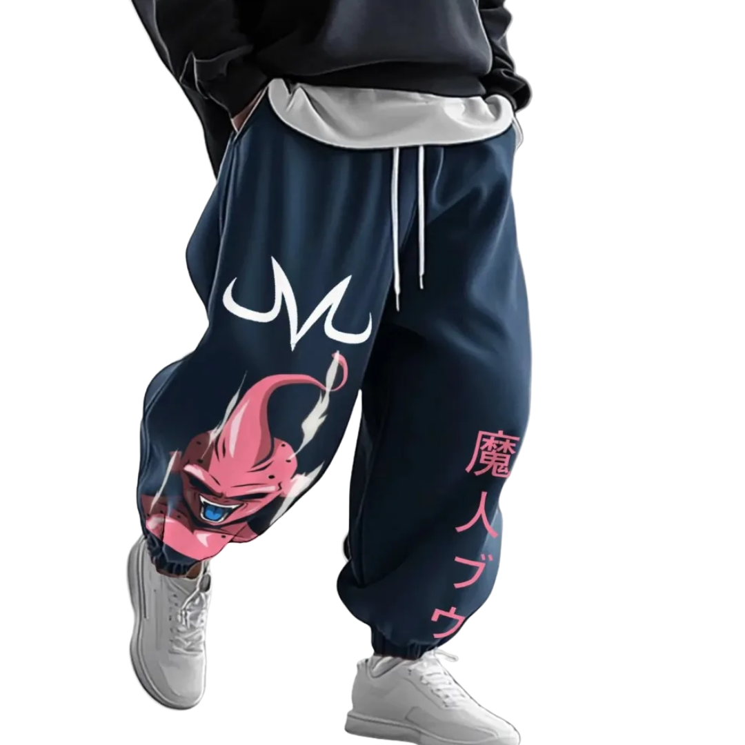A person wearing loose navy blue sweatpants with a large pink cartoon character graphic on one leg, white drawstrings, and pink Japanese text on the other leg, paired with white sneakers against a plain white background.