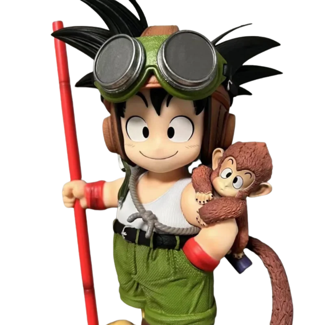 A stylized collectible figure of a cartoon boy with goggles and a red staff, holding a small brown monkey on his shoulder, shown against a plain white background.