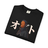 A folded black t-shirt featuring a graphic print of the anime character Otsuchi with his signature orange mask and the Japanese katakana text 'ざせ' in cream, displayed on a clean white background.