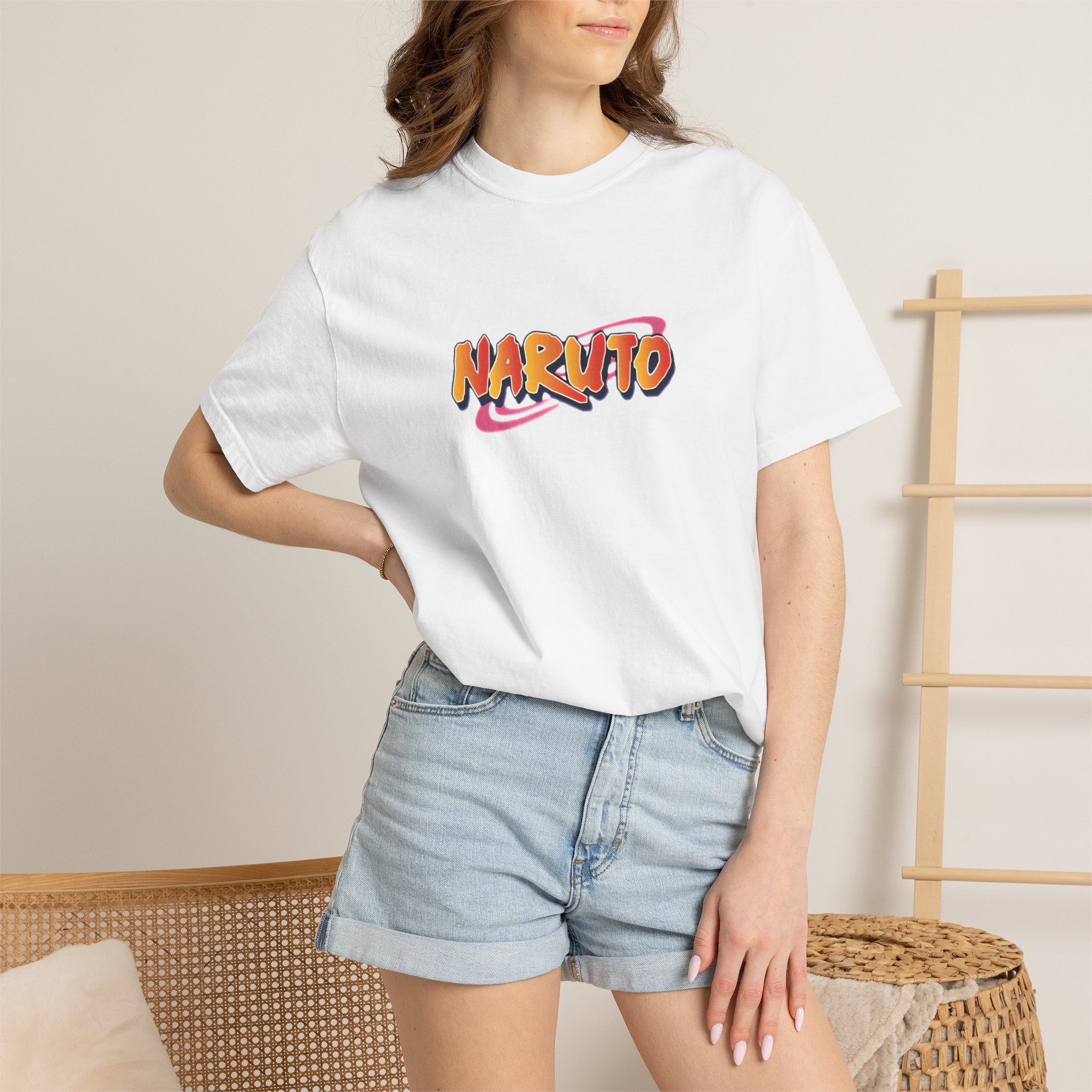Person wearing a white t-shirt with 'Jesus Heals' design and denim shorts indoors.