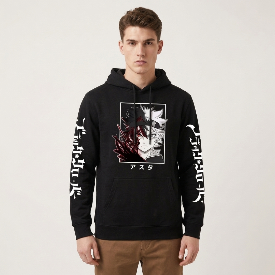 A man wearing a black pullover hoodie with a graphic print of two anime characters on the chest, white Japanese text down both sleeves, and a kangaroo pocket, paired with brown pants, against a plain light gray background.