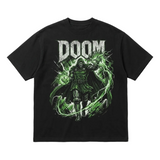A black short-sleeve graphic t-shirt featuring a large print of the video game character Doom with the word 'DOOM' in distressed white letters above him, on a light gray background.
