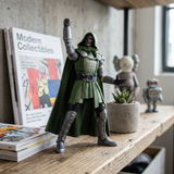 A green and silver Doctor Doom action figure stands on a wooden shelf in a styled room setting, with a book titled 'Modern Collectibles' on the left and small decorative items in the background.