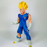 A detailed collectible action figure of Vegeta in a Super Saiyan form, featuring spiky yellow hair, a torn blue jumpsuit, and white arm and leg wraps, posed against a neutral light gray background.