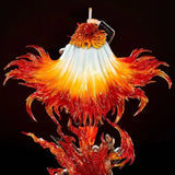 Colorful glass sculpture with vibrant orange, red, and yellow flames on a black background