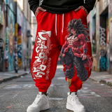 Red Dragon Ball Z sweatpants with a large anime graphic of Goku and Dragon Ball printed on the front, worn by a person standing on a city street.