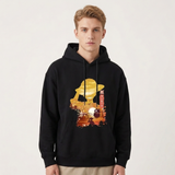 A man wearing a black pullover hoodie with a large graphic print on the front. The graphic features a stylized golden-yellow silhouette of a person in a hat against a sunset-like background with red and orange tones.