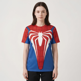 A woman modeling a short-sleeve crewneck t-shirt featuring a red and blue Spider-Man-inspired web pattern with a large white spider emblem on the front, set against a plain light gray studio background.