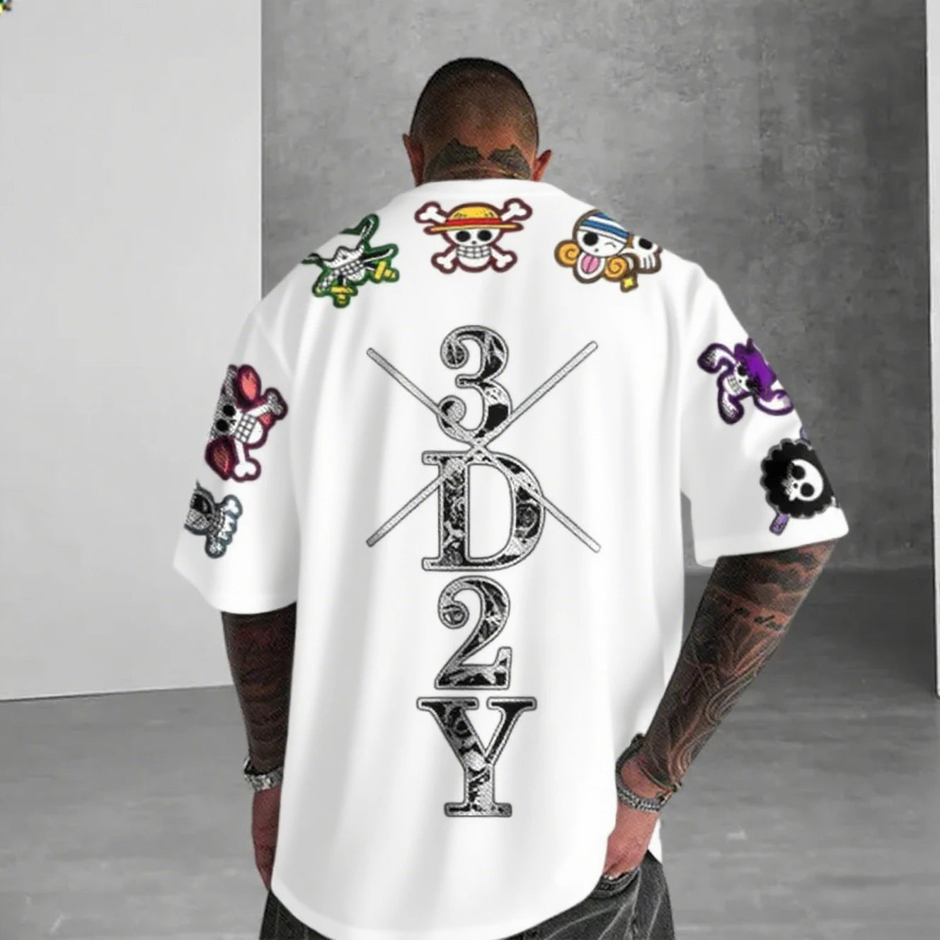 Person wearing a white t-shirt with colorful designs and text on the back, standing against a gray background.